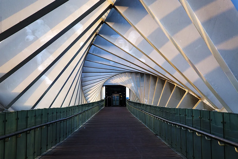 Colour photograph of a covered walkway with twisting geometric beams